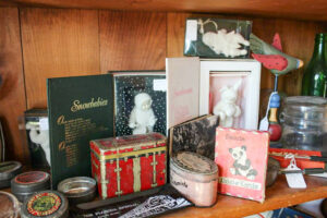 A wooden shelf with a variety of antique items on it.