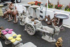 A display of garden statues in a parking lot.