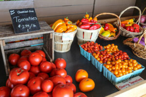 Tomatoes and peppers in baskets at a farm market