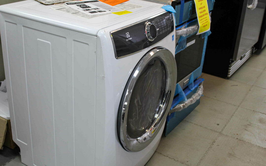 Slate Road Supply Ephrata PA Front-loading washing machine in a store, displayed on a blue pallet, with control panel and instructions visible.