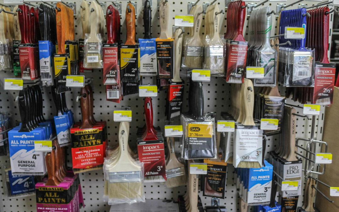 Slate Road Supply Ephrata PA Assortment of paintbrushes and paint rollers hanging on a pegboard in a hardware store.