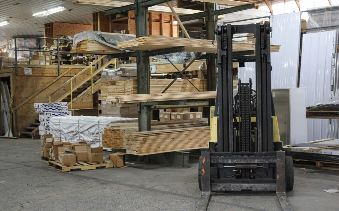 Slate Road Supply Ephrata PA A forklift parked in a warehouse surrounded by stacks of wooden planks and various building materials.