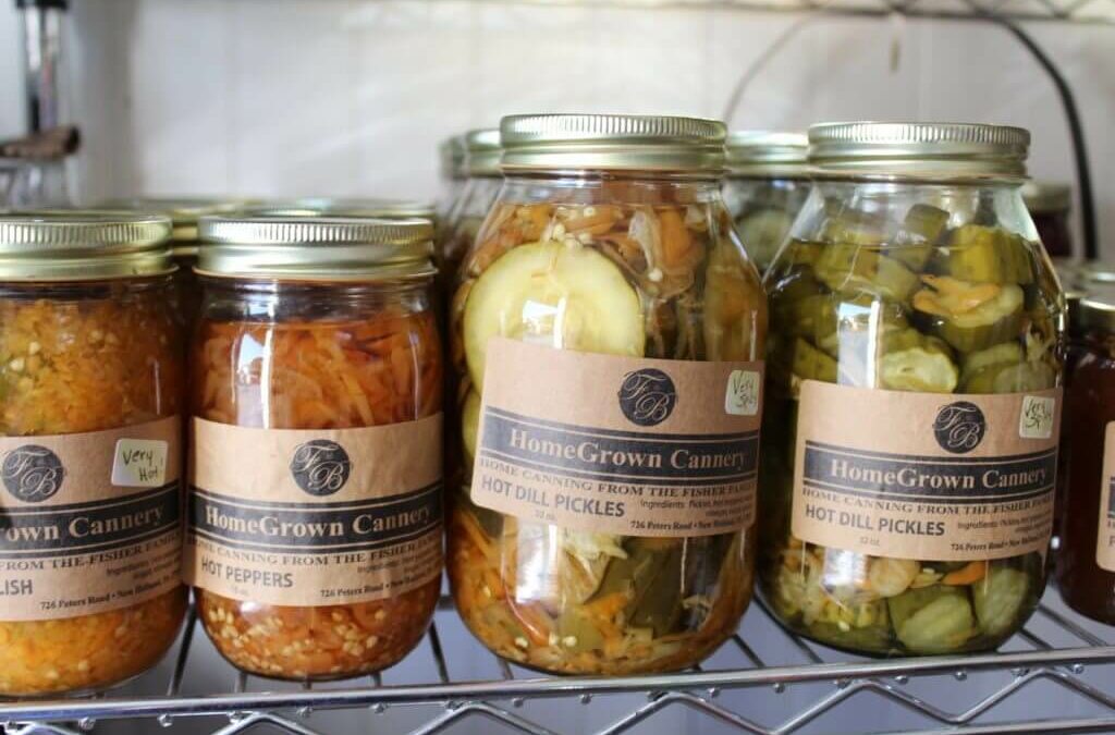 Homegrown Cannery Stand New Holland PA Jars of homegrown canned goods, including hot dill pickles and hot peppers, are arranged on a metal shelf. Each jar has a HomeGrown Cannery label.