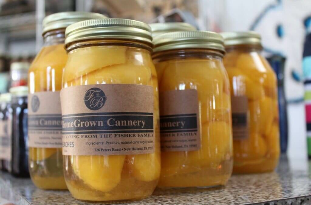Homegrown Cannery Stand New Holland PA Jars of canned peaches with "HomeGrown Cannery" labels displayed on a shelf.