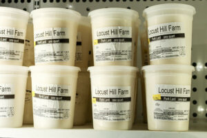 Containers of Locust Hill Farm Pork Lard on a supermarket shelf.