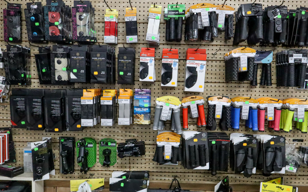 Weaver's Bike Shop Ephrata PA A store display featuring various bicycle accessories, including locks, grips, handlebar tape, and other bike-related items, hanging on a pegboard wall.