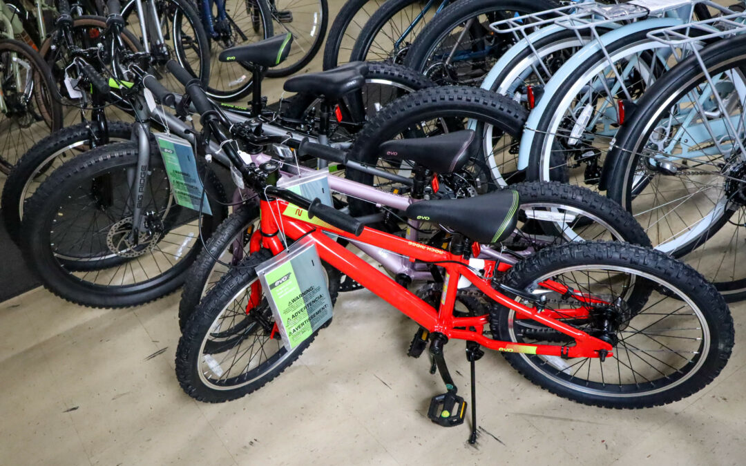 Weaver's Bike Shop Ephrata PA A row of colorful children's bicycles with price tags is displayed in a store. They feature thick tires and are arranged side by side on a tiled floor.