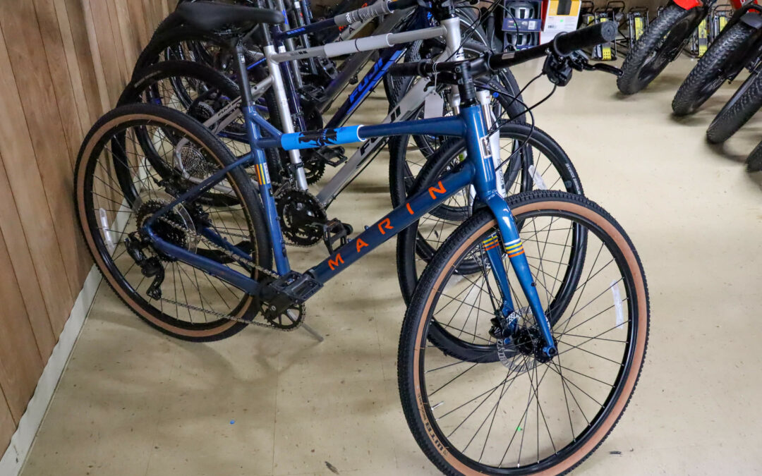 Weaver's Bike Shop Ephrata PA A blue Marin bicycle is displayed in a row of bikes in a store, leaning against a wooden wall.