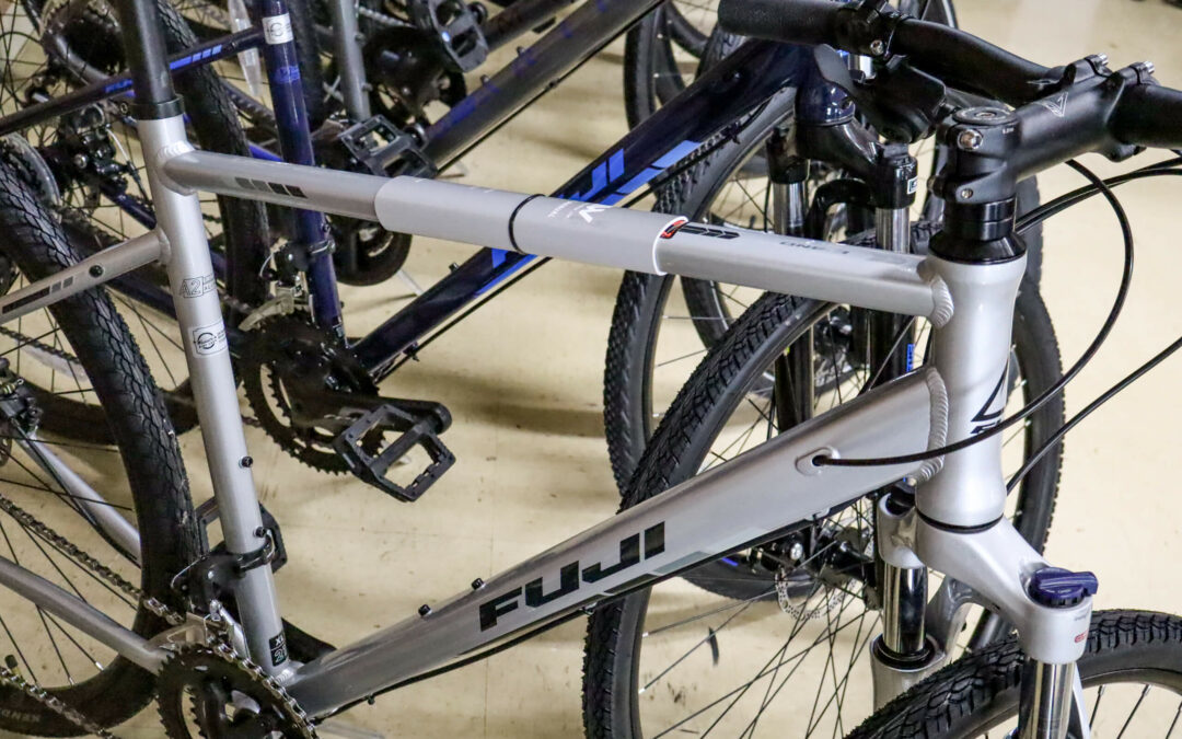 Weaver's Bike Shop Ephrata PA Several bicycles are parked closely together indoors, including a silver one in the foreground labeled "FUJI.