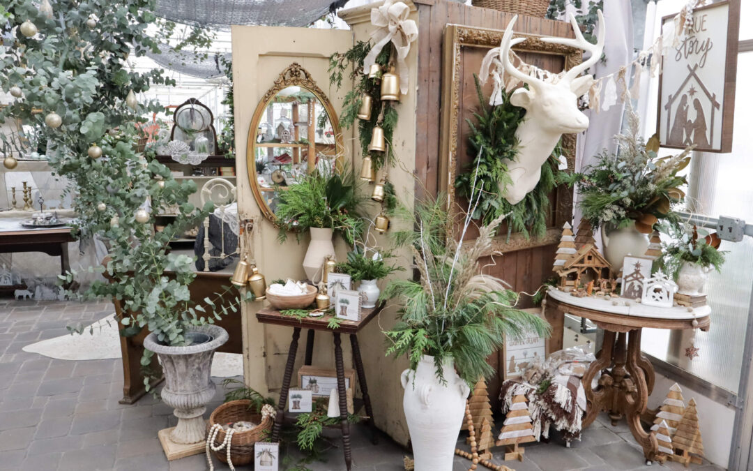 Reiff's Farm Market Ephrata PA A rustic Christmas display with greenery, a white stag head, ornaments, and decorative items, including small trees and framed pictures, arranged in a cozy setting.