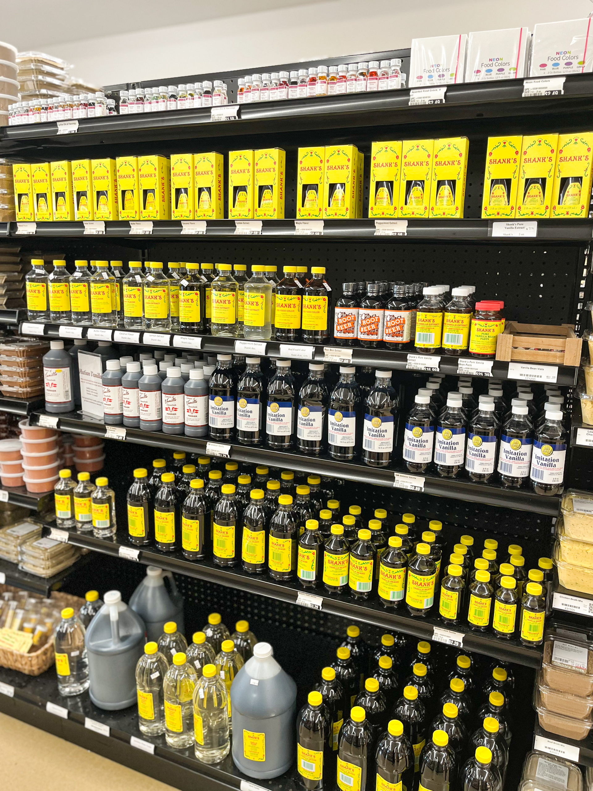 11.24.25 The Country Store Gallery 1-5 Shelves in a store stocked with various sizes and types of soy sauce bottles and packages, most with yellow labels, organized neatly in rows.