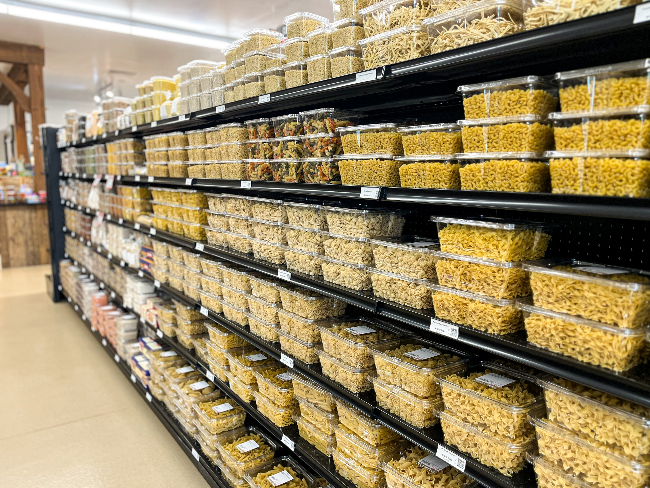The Country Store Mount Joy PA Shelves in a grocery store filled with various types of dried pasta in clear plastic containers.