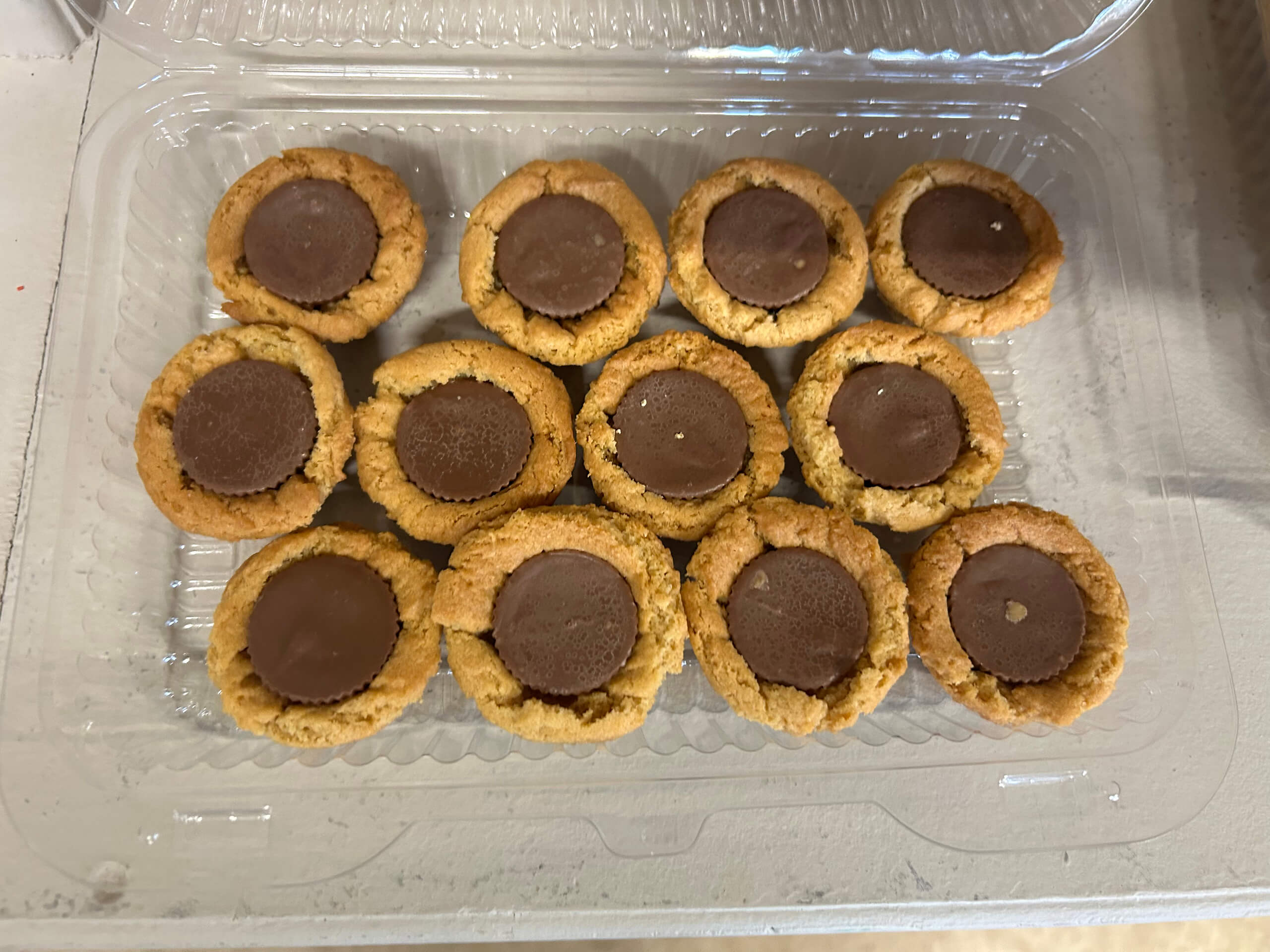 Turtle Hill Farm Market Leola PA A plastic container holding twelve peanut butter cookies topped with chocolate candy centers, arranged in three rows.
