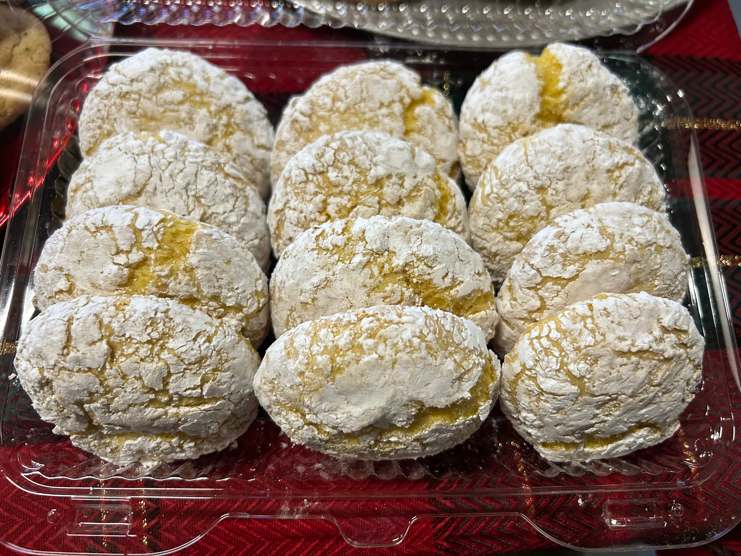 Turtle Hill Farm Market Leola PA A plastic container holds twelve yellow cookies coated in powdered sugar, arranged in three rows of four.