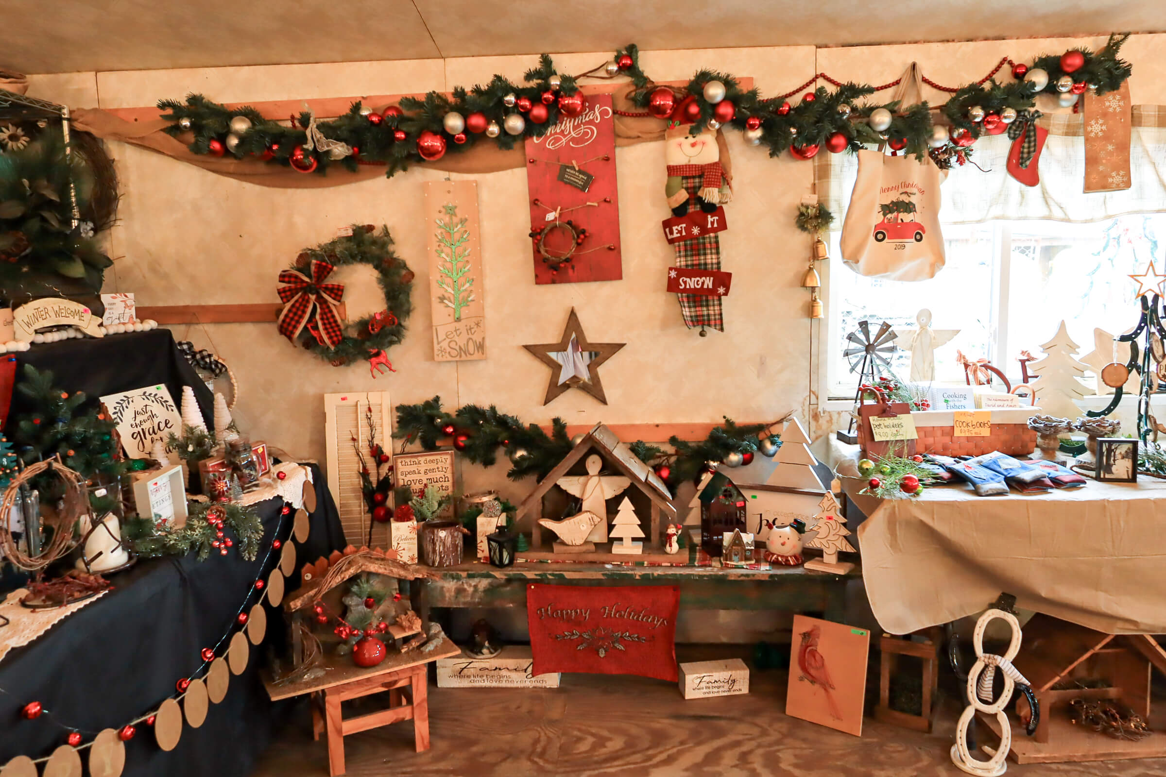 Busy Bee's Farm Market Ronks PA Room decorated for Christmas with garlands, ornaments, signs, and various holiday-themed crafts displayed on tables and shelves.