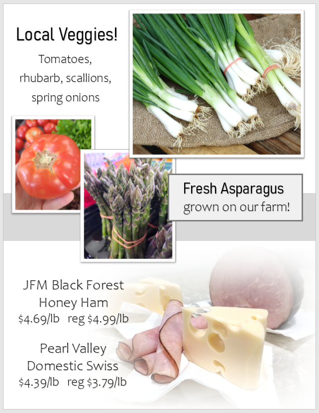 Display of local vegetables including tomatoes, rhubarb, scallions, spring onions, asparagus, and featured deli meats and cheeses with prices.