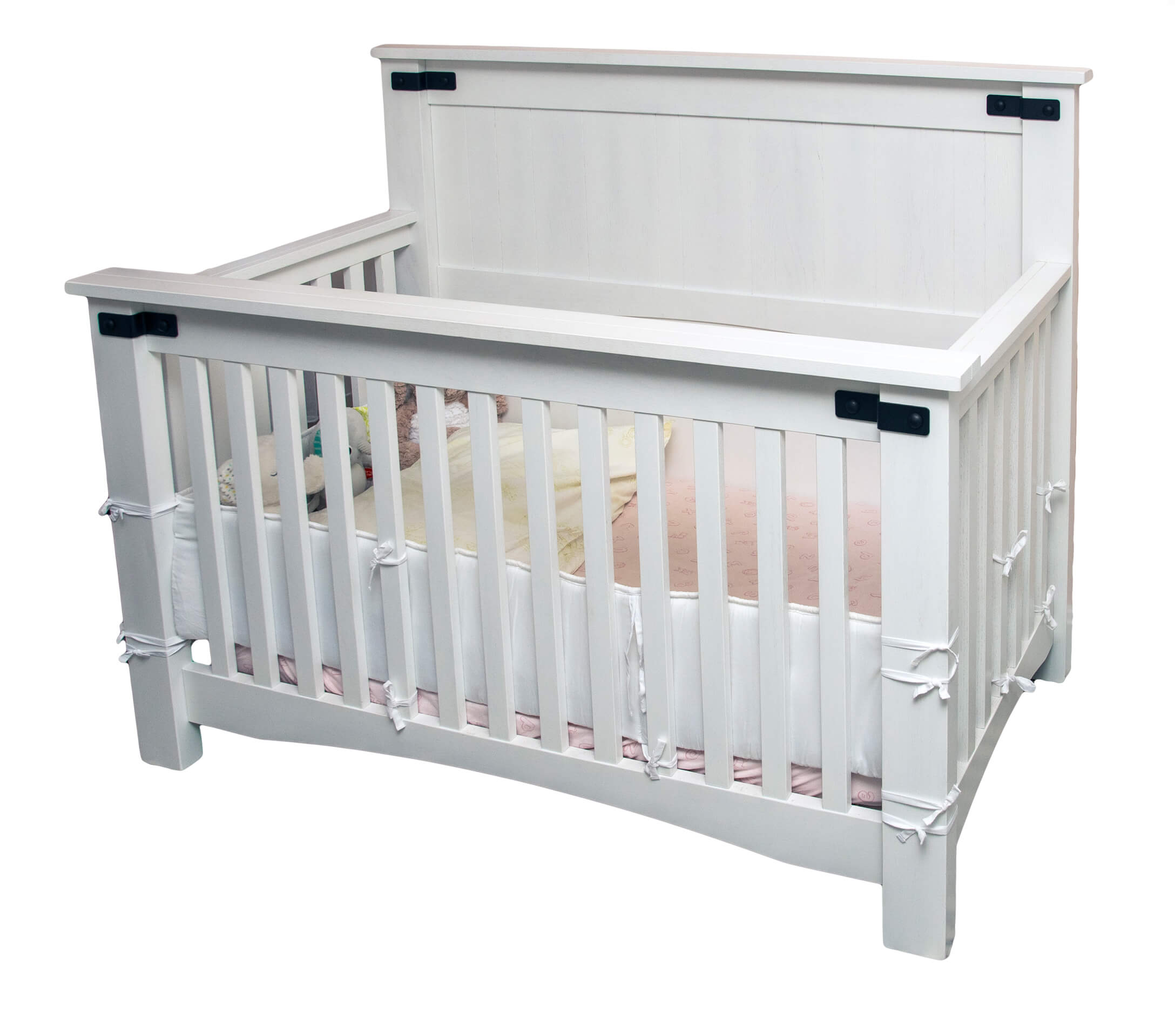 7.8.26 Spring Valley Woodworking Bedroom Gallery 7 White wooden crib with vertical slats, a high headboard and footboard, and a mattress with pale bedding inside.